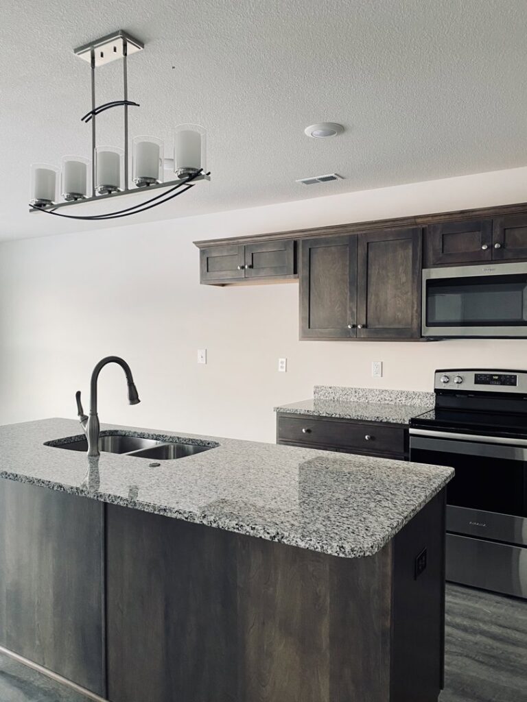 A clean kitchen featuring an island and dark cabinets, reflecting the meticulous cleaning services of Sudz Up Cleaning Company in Columbia, MO.