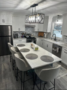 A bright and clean kitchen featuring a large island with bar stools, expertly cleaned by Mary's Sparkling Cleaning in Fall River, MA.