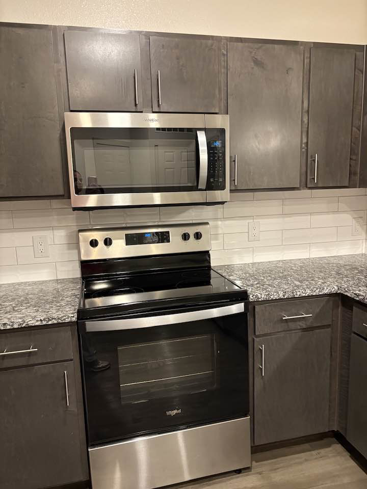 A clean kitchen with a sparkling oven and microwave, maintained by Jess Cleaning in San Antonio, TX.