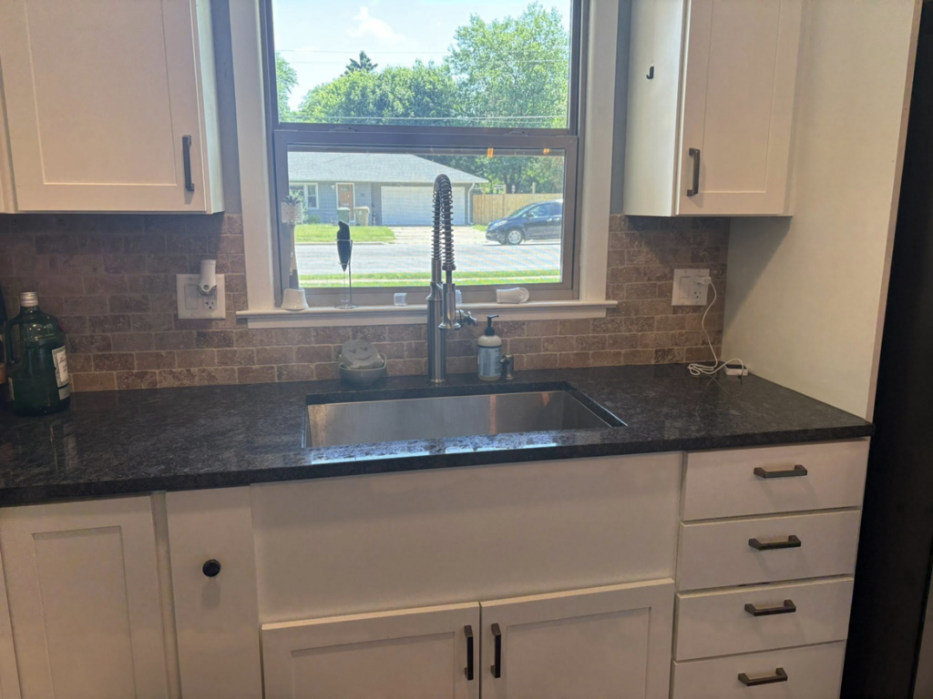 A clean kitchen sink and countertop, showcasing the results of Warm & Cozy House Cleaning in Madison, WI