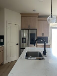 A tidy kitchen sink area with light wood cabinets, professionally cleaned by Martinez Cleaning Services in Kent, WA