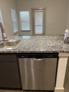 A clean kitchen sink and granite countertop, ready for use after Jess Cleaning service in San Antonio, TX.