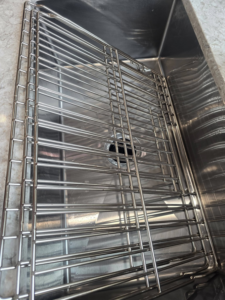 A shiny clean kitchen sink grate after professional cleaning by Wonderful Laura Cleaning in Aurora, IL.