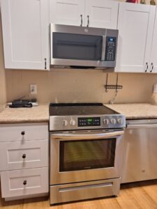 A bright and clean kitchen with white cabinets and stainless steel appliances, cleaned by Martinez Cleaning Services in Kent, WA