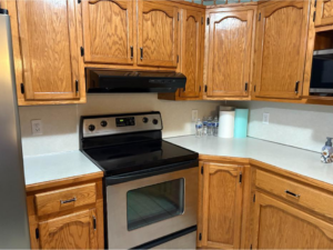 A spotless kitchen featuring clean wooden cabinets, a stainless steel stove, and tidy countertops by In Between Clean 2 in Greeneville, TN.