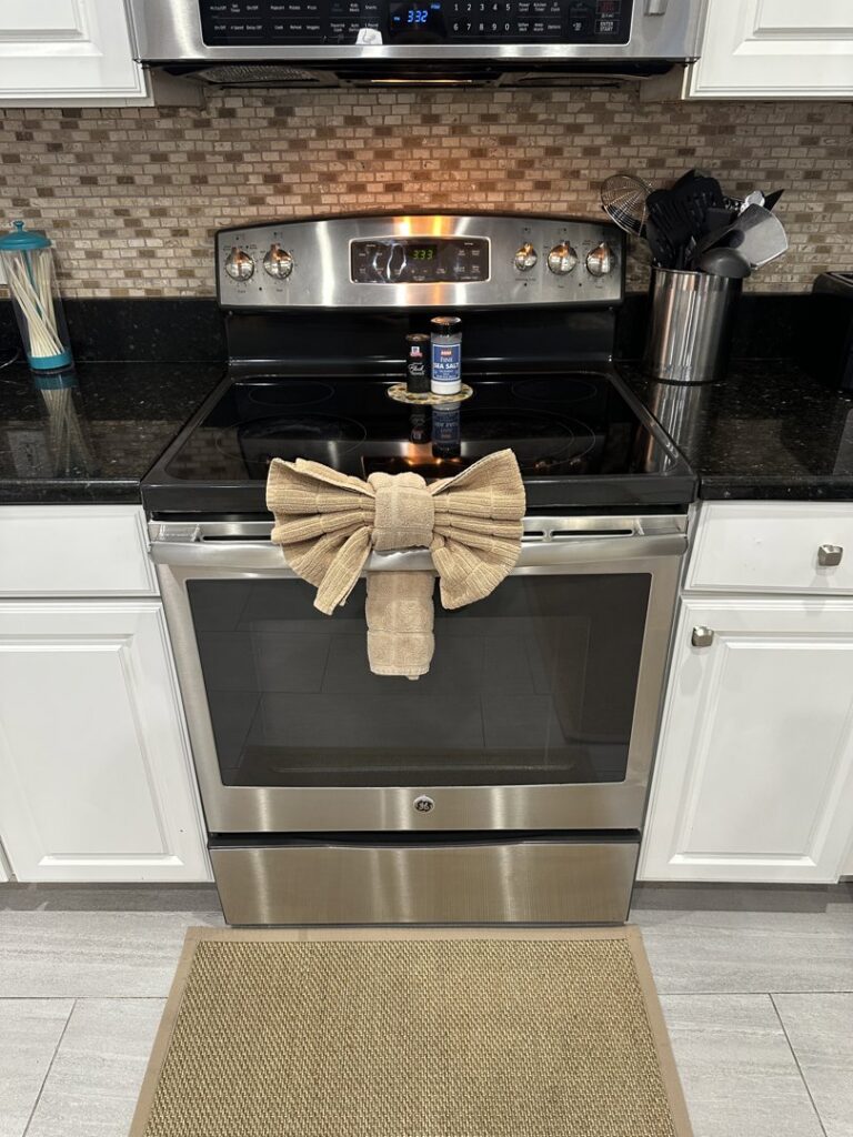 A meticulously cleaned kitchen stove with a decorative towel bow, a detail from Nichole's Cleaning Service in Fort Wayne, IN