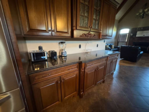 A clean kitchen with dark wood cabinets and granite countertops, showcasing MC'S cleaning & painting service in Knoxville, TN.