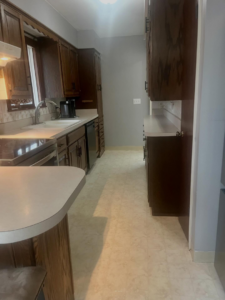 A beautifully clean kitchen featuring dark wood cabinets and light flooring, professionally cleaned by BLACK PEARL Cleaning CO. in Greenwood, MO.