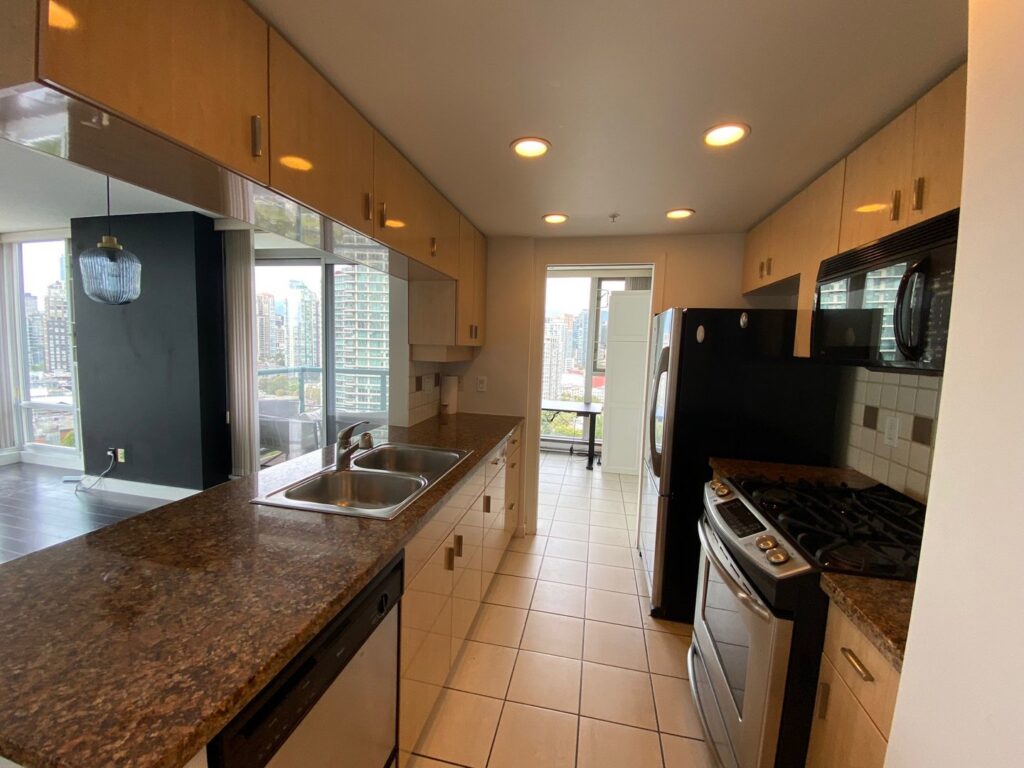 A professionally cleaned kitchen featuring light wood cabinets and dark countertops by Trust-Clean in Green Bay, WI.
