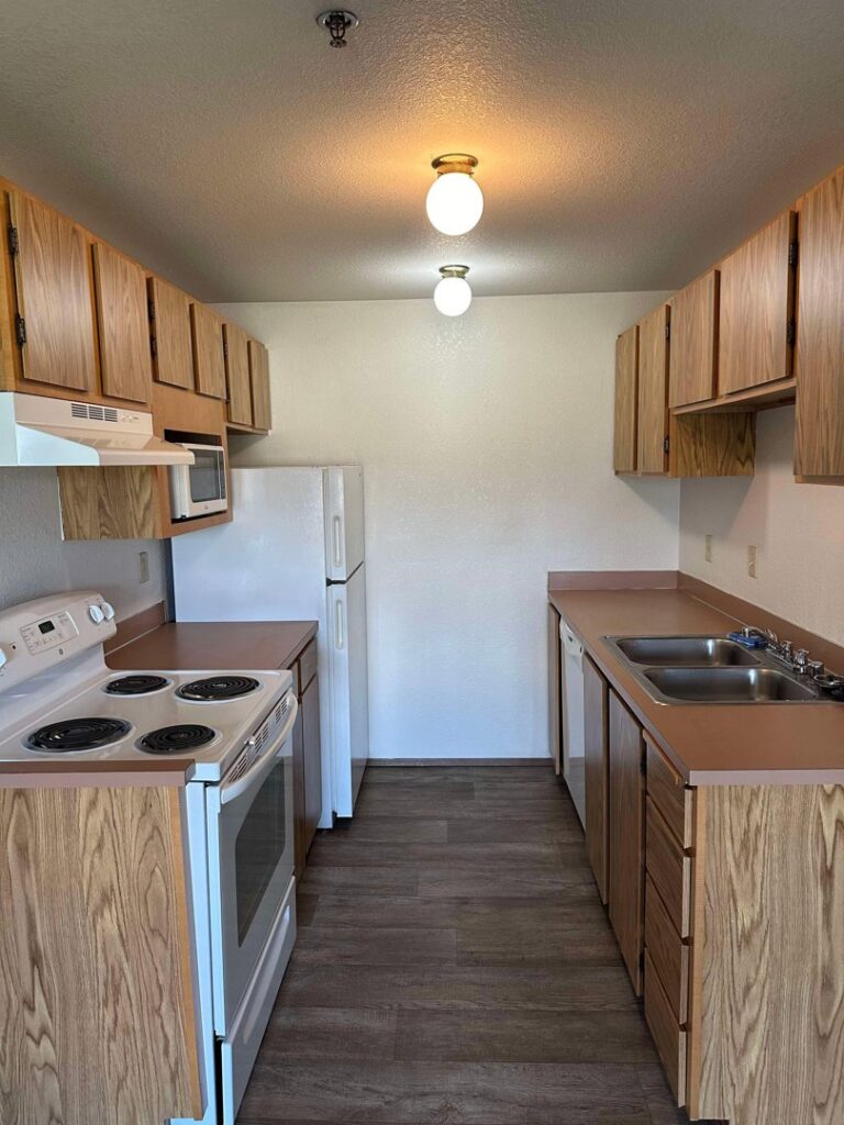 A clean kitchen with wooden cabinets and white appliances after professional cleaning by Nannie Needs LLC in Kent, WA.