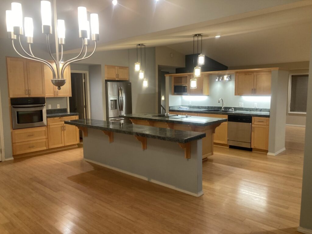 A bright and clean kitchen with light wood cabinets and dark countertops, reflecting the professional cleaning by E-N-S Home Cleaning Solutions, LLC in Lewiston, ID.