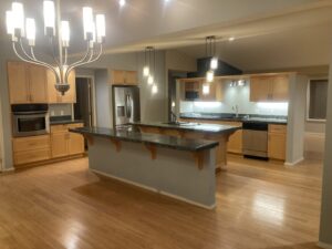 A bright and clean kitchen with light wood cabinets and dark countertops, reflecting the professional cleaning by E-N-S Home Cleaning Solutions, LLC in Lewiston, ID.