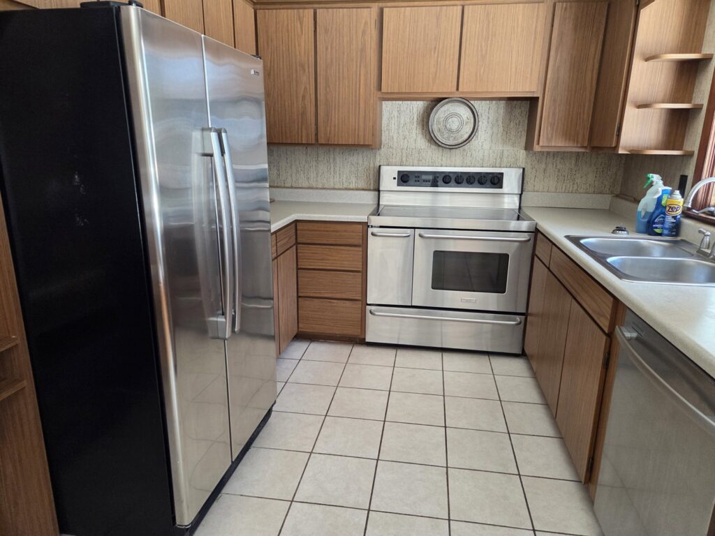 A clean kitchen with wooden cabinets and stainless steel appliances after professional cleaning by Hm General Cleaning Services in Schenectady, NY