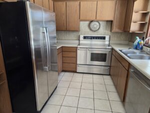 A clean kitchen with wooden cabinets and stainless steel appliances after professional cleaning by Hm General Cleaning Services in Schenectady, NY