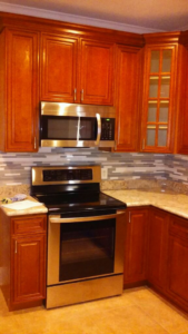 A sparkling clean kitchen with wooden cabinets and stainless steel appliances, cleaned by Foundation Janitorial Services in Monroe, LA.