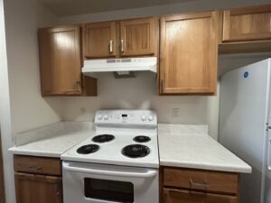A neat and clean kitchen with wooden cabinets and a white stove, cleaned by Martinez Cleaning Services in Kent, WA
