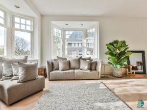 A bright and clean living room featuring a comfortable beige sofa and large windows, demonstrating the quality cleaning by CleanCo Works in Scottsdale, AZ.