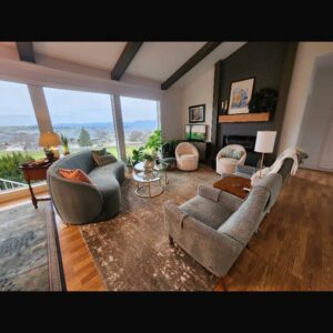 A beautifully cleaned living room with modern furniture and a large window offering a scenic view, maintained by E-N-S Home Cleaning Solutions, LLC in Lewiston, ID.