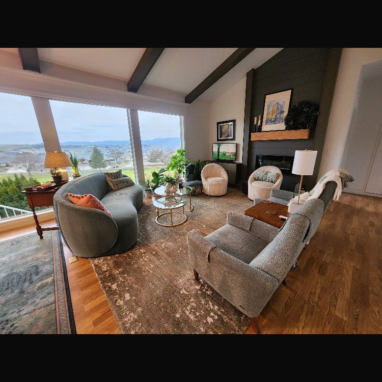 A beautifully cleaned living room with modern furniture and a large window offering a scenic view, maintained by E-N-S Home Cleaning Solutions, LLC in Lewiston, ID.