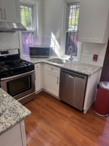A clean living room with a large grey sofa and shiny floors, reflecting the quality service of Statewide cleaning services llc in Philadelphia, PA.
