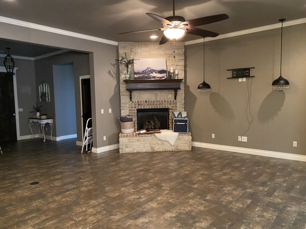 A clean and organized living room featuring a beautiful stone fireplace, maintained by Inspire Clean OKC in Oklahoma City, OK.