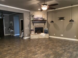 A clean and organized living room featuring a beautiful stone fireplace, maintained by Inspire Clean OKC in Oklahoma City, OK.