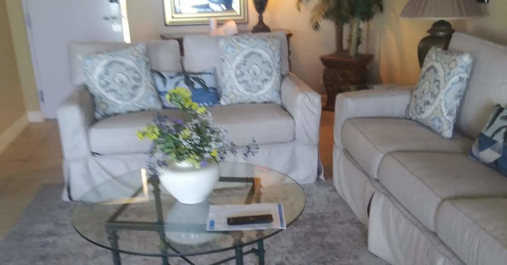 A sparkling clean living room with comfortable sofas and a coffee table, expertly cleaned by Tangie's Cleaning Service in Syracuse, NY.