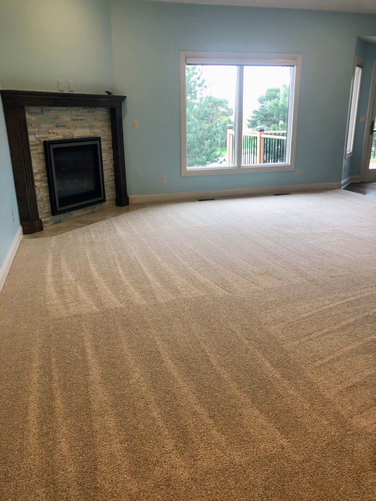 A freshly cleaned living room with a fireplace and vacuumed carpet, provided by Price Cleaning Services Omaha in Council Bluffs, IA.