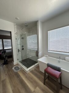 A clean master bathroom with a large glass shower and freestanding tub, showing the results of JG Clean Solutions in Henderson, NV.