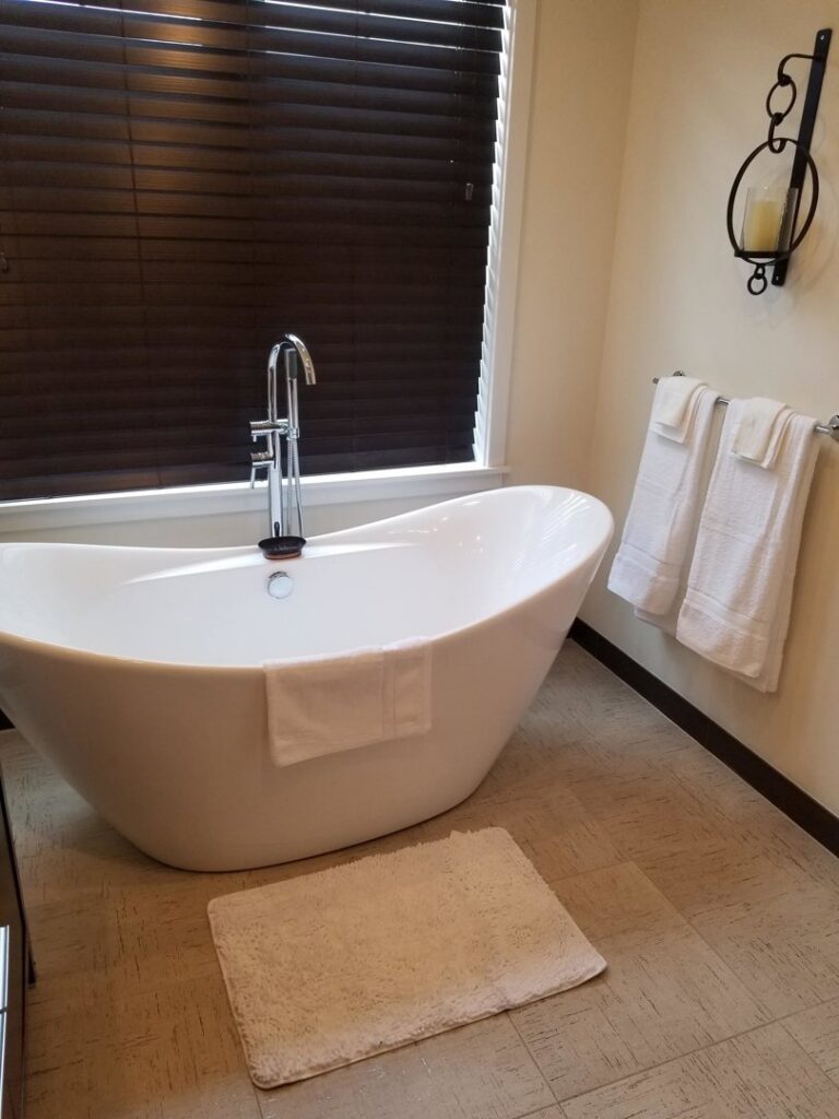 A clean modern bathroom featuring a freestanding white bathtub by Cooper-N-Folks in Philadelphia, PA