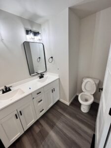 A sparkling clean, modern bathroom with a double vanity and wet floor, demonstrating a thorough cleaning by Cedar Cleaners LLC in Cedar Rapids, IA.
