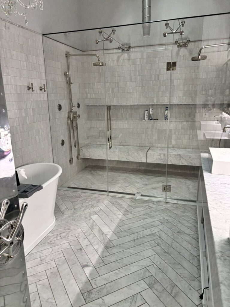 A pristine modern bathroom with a large glass shower and freestanding tub, expertly cleaned by Bee Clean Solutions in Lexington, KY.