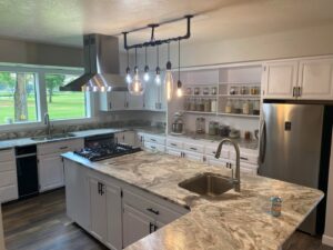 A spacious and clean modern kitchen with white cabinets and a large island, reflecting the quality cleaning by E-N-S Home Cleaning Solutions, LLC in Lewiston, ID.