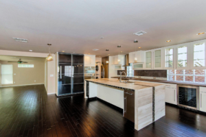 A sparkling clean, modern kitchen and living area with dark wood floors after a professional house cleaning by BATman Janitorial in Post Falls, ID.