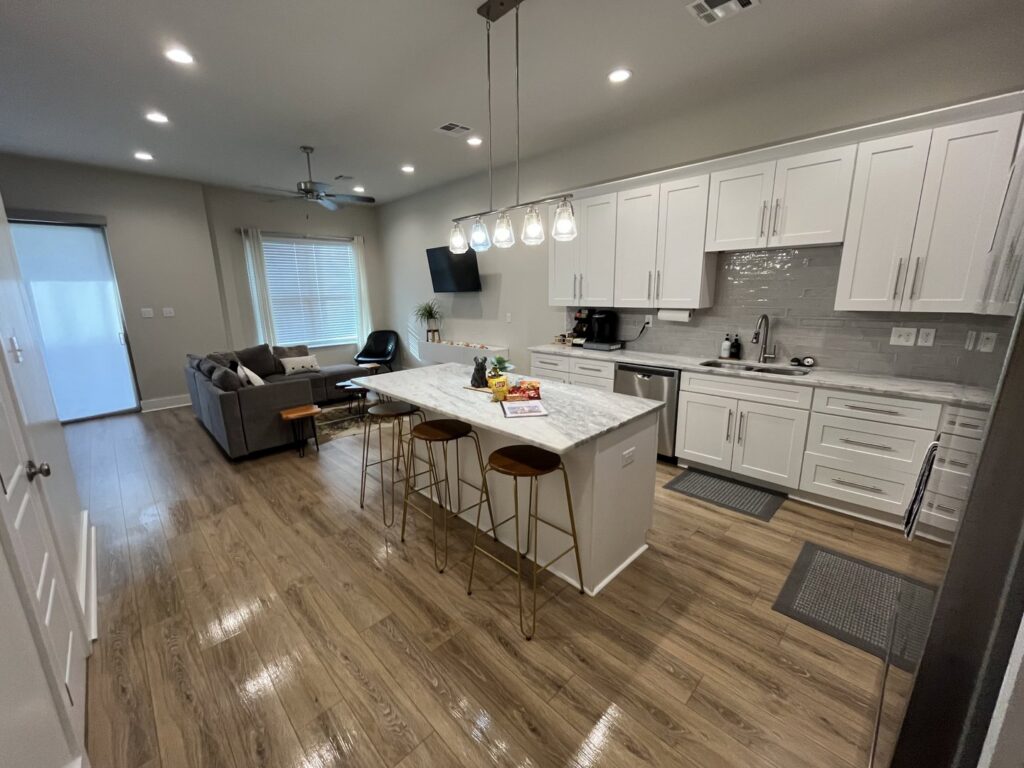A sparkling clean modern kitchen and living room, showcasing the results of Bolt Enhanced Cleaning Solutions in Scott, LA.