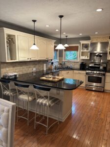 A sparkling clean, modern kitchen with light cabinets and dark countertops, cleaned by Maid In Indy in Indianapolis, IN.