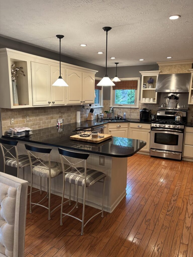 A sparkling clean, modern kitchen with light cabinets and dark countertops, cleaned by Maid In Indy in Indianapolis, IN.