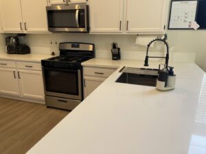 A beautifully clean modern kitchen with white cabinets and stainless steel appliances by Picky Performance Cleaning in North Las Vegas, NV