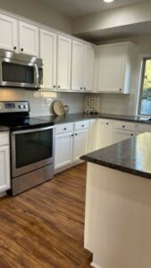 A clean, modern kitchen with white cabinets and stainless steel appliances, cleaned by Price Cleaning Services Omaha in Council Bluffs, IA.