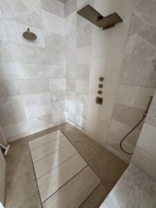A clean and modern shower with light-colored tiles, demonstrating Kleen Slate's thorough bathroom cleaning in Shakopee, MN.