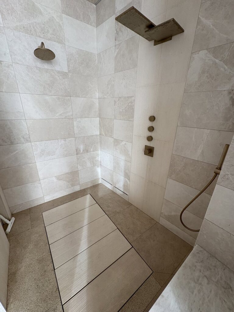 A clean and modern shower with light-colored tiles, demonstrating Kleen Slate's thorough bathroom cleaning in Shakopee, MN.