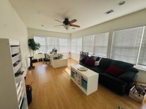 A spacious, clean, and organized living room with a desk and sofa by Consciously Cleared & Contained LLC in Elsmere, DE.