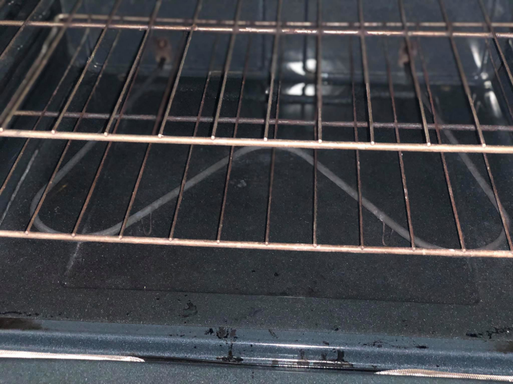 A sparkling clean oven interior with racks, showcasing professional house cleaning by Refresh Cleaning Company in Hazelwood, MO.