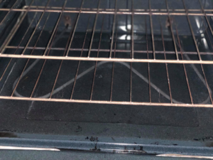 A sparkling clean oven interior with racks, showcasing professional house cleaning by Refresh Cleaning Company in Hazelwood, MO.