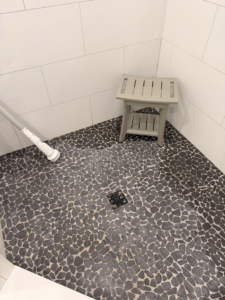A sparkling clean pebble-tiled shower floor after professional cleaning by Jocelyn's Cleaning Services in Charlotte, NC.