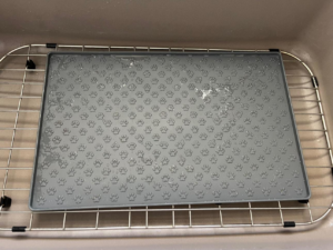 A clean pet feeding mat resting in a kitchen sink, sparkling after a thorough cleaning by Spotless by Sam LLC in Green Bay, WI.