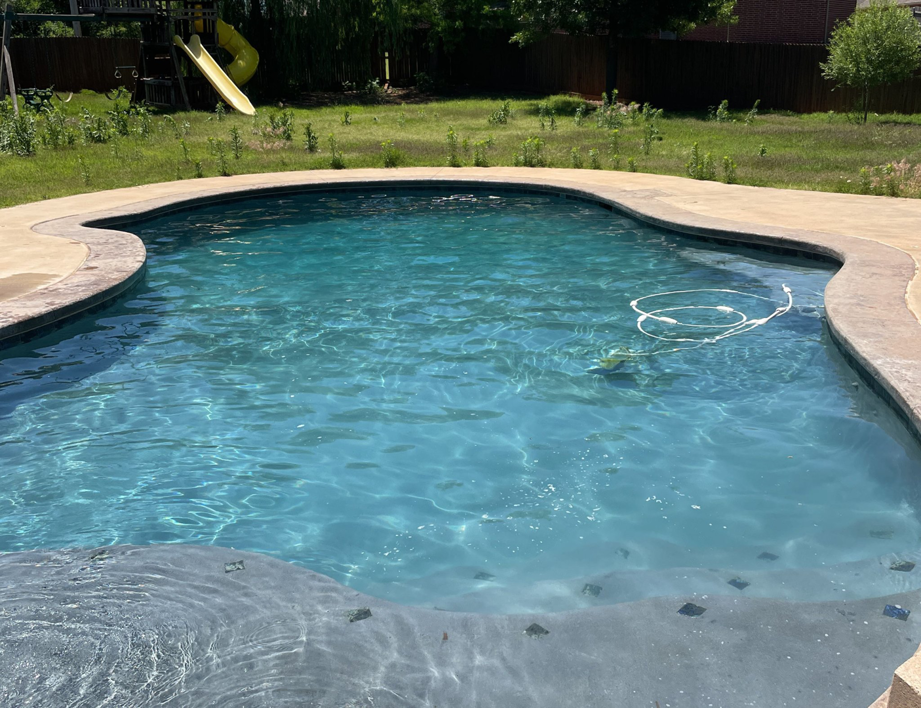 A clean swimming pool with a vacuum hose visible, indicating ongoing maintenance by AquaDocs in Dublin, OH.