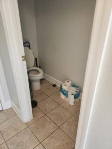 A clean powder room with a toilet and tiled floor, demonstrating the thorough cleaning services of S&M Cleaning Services 5 LLC in Cocoa, FL.