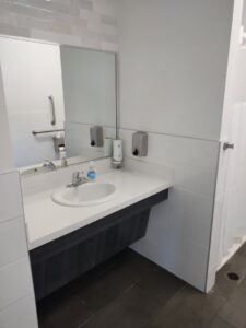 A clean public restroom vanity with a sink and mirror, maintained by Green Leaf Janitorial in Gilbert, AZ.