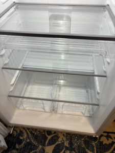 Crystal clear glass shelves and drawers in a refrigerator, expertly cleaned by Sprinkled Clean in Bangor, ME.